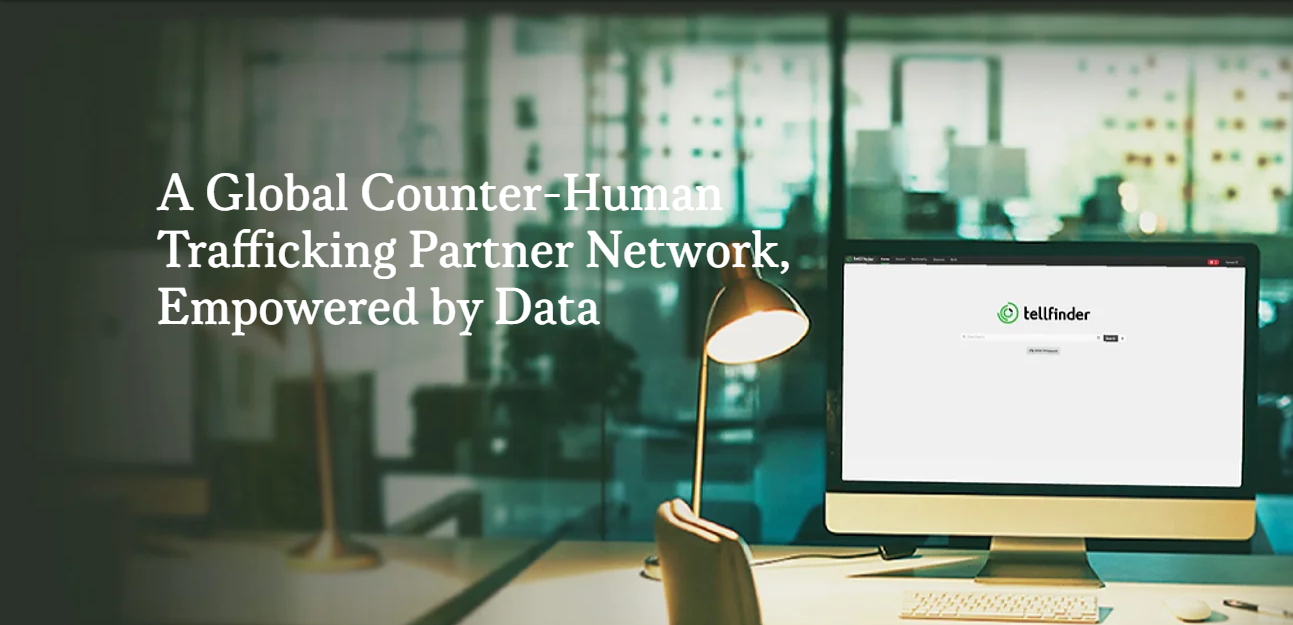 A Global Counter-Human Trafficking Partner Network, Empowered by Data A desktop with a desk lamp and a monitor showing the TellFinder search bar.