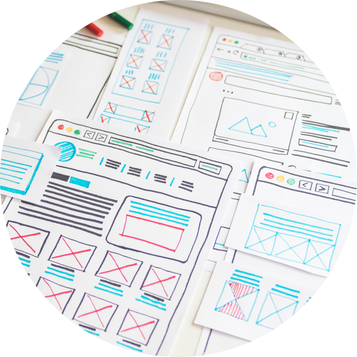 Many overlapping web application wireframe designs on a drafting table.